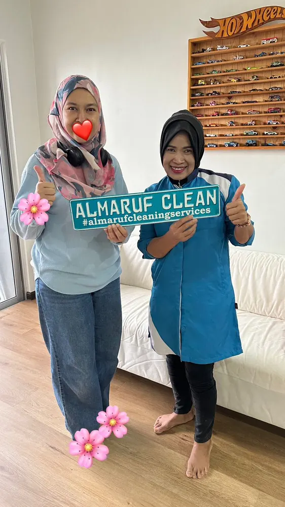 Almaruf Clean cleaner holding the Almaruf Clean sign with a customer after the job